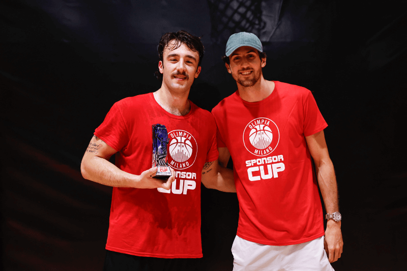 Tommaso Castano della Farmacia Pavanetto premiato come miglior giocatore della Sponsor Cup Olimpia, con in mano la coppa del primo posto accanto a un giocatore dell’Olimpia Milano.